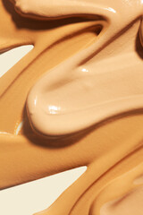 Set of different textures of cosmetic foundation, concealer, highlighter, soft powder, bronzer, on beige background