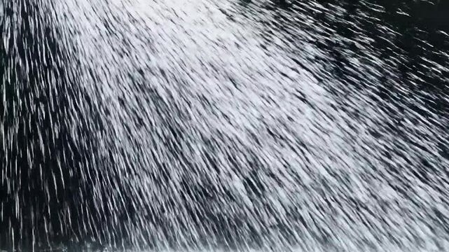 Heavy water spray falling diagonally against a dark background