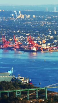 Vertical video: Motorboat entering causing wakes and ripples, cranes holding, showing port activity