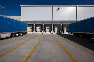 trucked trailers parked in front of distribution warehouse