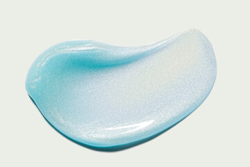 Cosmetic purple metallic holographic shimmering luminizer body lotion oil gel or shower gel texture on isolated neutral grey surface