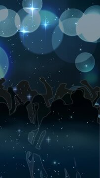 Vertical video: Bokeh shifting and sparkles twinkling, silhouetted crowd dancing for concert loop