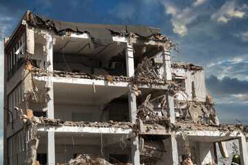 Demolition of an old building using heavy construction equipment. A scene showing the dismantling process, debris, and site preparation for a new development. © jarizPJ