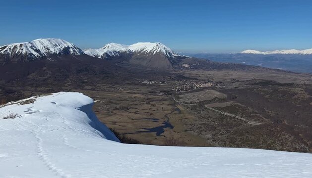 Snowy ridge of Monte Sirente with spectacular snow cornice, overlooking the Apennines and Rovere village, Abruzzo, Italy