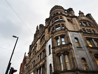 Naklejka premium Historic Manchester building with ornate stone facade and tall windows along a grand urban Clarence street