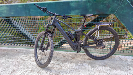 Fototapeta premium Mountain e-bike with luggage rack on a metal bridge