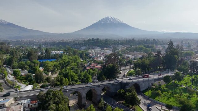 Aerial view of the Chilina bridge, the Chilina valley and the Misti volcano during the rainy season with the snow-capped volcano in Arequipa, Peru
