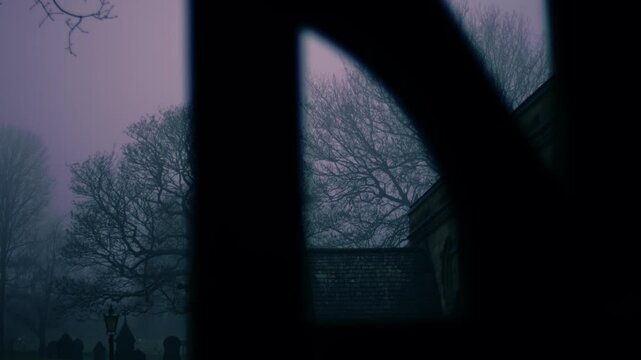 Lonely Graveyard on foggy day though view of lych gate