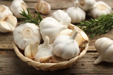 Fresh garlic and rosemary on wooden table, closeup