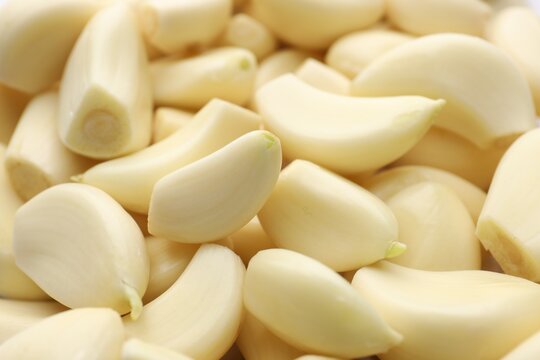 Fresh peeled garlic cloves as background, closeup