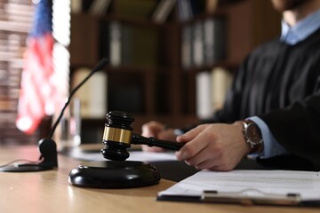 Judge striking gavel at table indoors, selective focus © New Africa