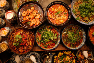 A table laden with numerous bowls of Korean national cuisine, from banchan to stews, capturing the essence of a traditional Korean meal.