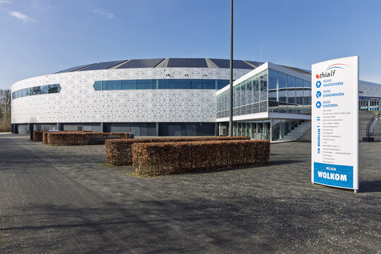 Modern architecture of Thialf ice arena in Heerenveen, Netherlands. Features honeycomb facade, entrance signs, and clear blue sky on sunny day. Heerenveen, Netherlands, 26 february 2026