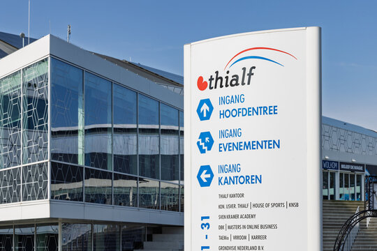 Information sign at Thialf ice arena in Heerenveen. Shows directions for main entrance, events, and offices against modern glass architecture. Heerenveen, Netherlands, 26 february 2026
