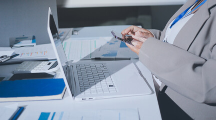 Business colleagues analyzing financial charts and reports on the table while having a focused discussion about strategies and market performance during an important meeting in a modern office setup