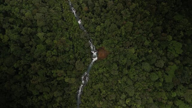 Top down circling aerial over Rio celeste river in Costa Rica lush green rain forest
