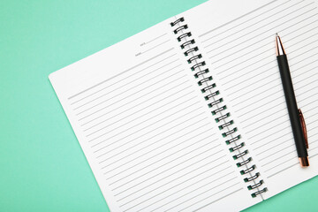 Open notepad and pen on mint background. Space for writing. © Mouse family