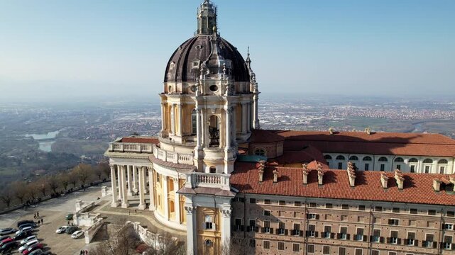 Aerial drone view of the majestic Basilica of Superga and its monastery buildings on the hilltop in Turin, Italy, historic baroque architecture, city panorama, sunny daylight.