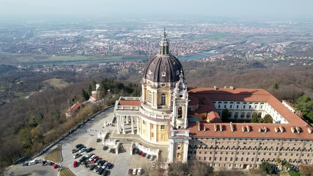 Aerial drone view of the majestic Basilica of Superga and its monastery buildings on the hilltop in Turin, Italy, historic baroque architecture, city panorama, sunny daylight.