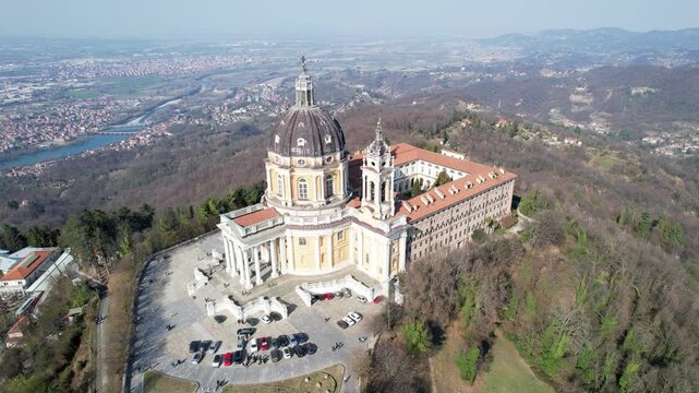 Aerial drone view of the majestic Basilica of Superga and its monastery buildings on the hilltop in Turin, Italy, historic baroque architecture, city panorama, sunny daylight.