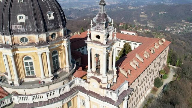Aerial drone view of the majestic Basilica of Superga and its monastery buildings on the hilltop in Turin, Italy, historic baroque architecture, city panorama, sunny daylight.