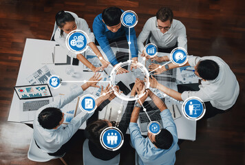 A diverse business team collaborates in a modern office, analyzing charts and KPI metrics to drive...