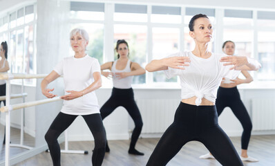 Fototapeta premium Graceful women of different ages practice various ballet movements in a choreographic studio