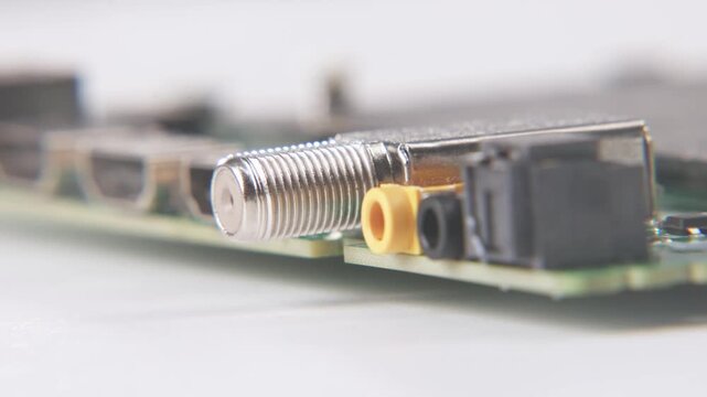 Close up view and blurred focus of opened technology motherboard mother board electronics of broken TV television ports like HDMI video, ethernet, T-con ribbon cables, component, and audio input open