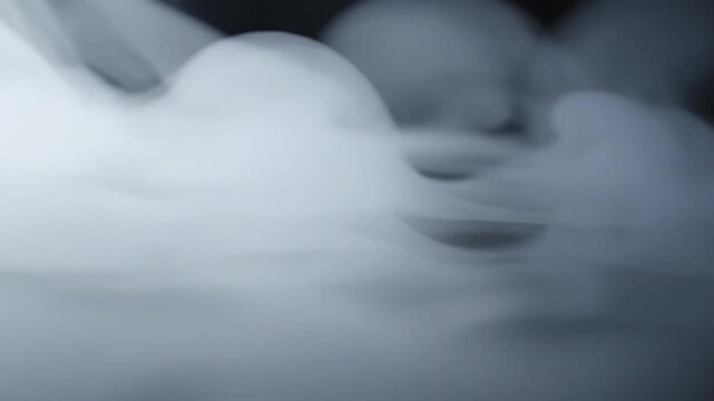 A moody, abstract image of swirling white smoke against a dark background. Ideal for representing mystery, uncertainty, or dramatic concepts in design