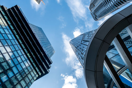 Curved modern glass skyscraper architecture in Frankfurt Germany delivers dramatic perspective for an urban finance setting under a wide open sky