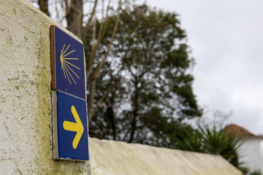 Camino de santiago waymarking scallop shell yellow arrow sign