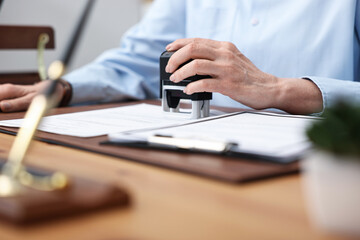 Fototapeta premium Notary stamping document at desk in office, closeup