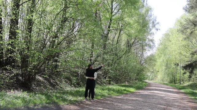 a young couple walking along a road in a spring forest