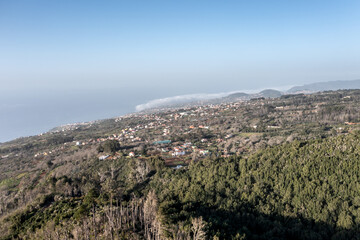 Obraz premium Aerial view of Tenerife forest meeting the ocean coastline with coastal villages below