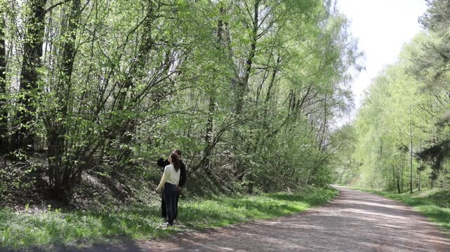 a young couple in love walking through a blooming spring park
