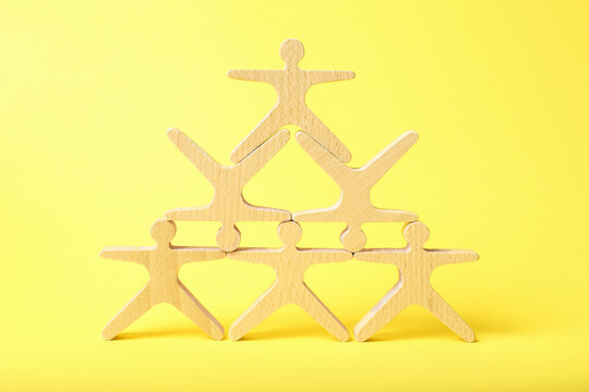 Wooden human shaped figures on yellow background