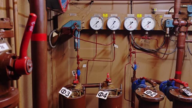 Tight shot of pressure dials, labeled filters and red levers in maintenance bay technician action implied replacing seals, logging readouts and enabling predictive maintenance analytics for industry.