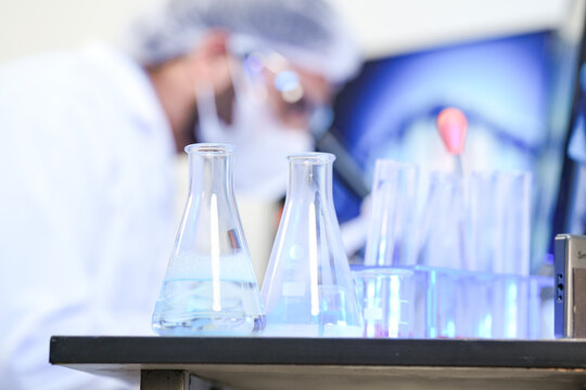 Analytical chemist adhering to strict cleanroom PPE compliance during quality control inspection. Laboratory technologist verifying volatile chemical solvent integrity.