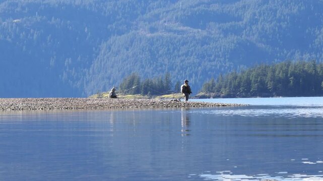 People fishing at the Green Point Day Use Area at the Sasquatch Provincial Park near Harrison Hot Springs during a winter season in Fraser Valley, British Columbia, Canada