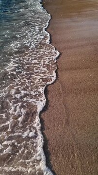 Vertical Sunset Waves on Golden Sandy Beach