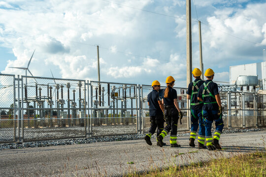 Civil engineering contractors conducting operational logistics assessment at industrial construction site. Project management team walking towards utility control building.