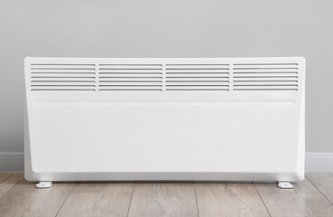 Electric convector heater near light wall