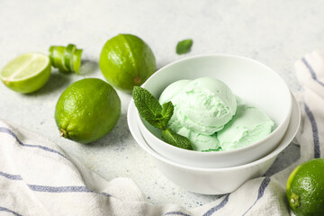 Bowl with lime ice cream and mint leaves on light grunge background © Pixel-Shot