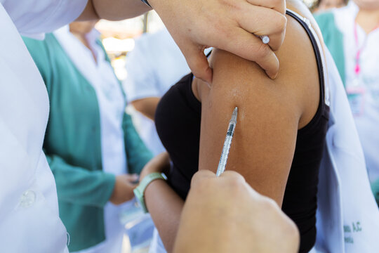 Measles vaccine administration in Mexico health campaign. Healthcare worker injecting a vaccine dose into a patient's arm