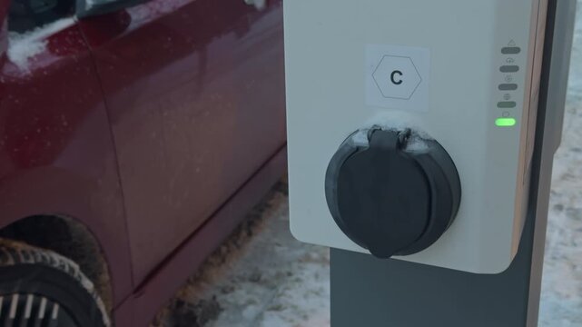 Charging port connected with illuminated status indicators. Cold weather compatible electric vehicle charging with detailed closeup view