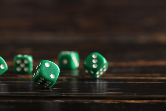Green game dices on wooden background