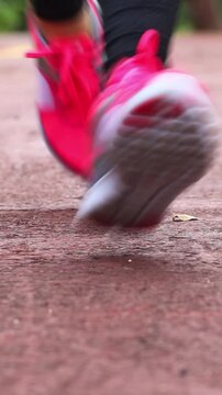 Woman jogging in the park. Healthy lifestyle and sport concept. Vertical footage