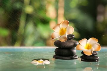 Lake with spa stones and beautiful plumeria flowers in tropical bamboo garden