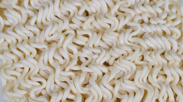Noodle texture closeup. Macro shot of tangled uncooked noodles surface. High detail macro photograph depicting intricate surface patterns of uncooked instant noodles