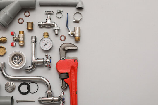 Set of plumber's items on grey background